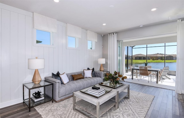 living room featuring hardwood / wood-style flooring and a water view