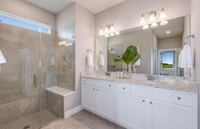 bathroom featuring a shower with shower door, vanity, and tile patterned floors