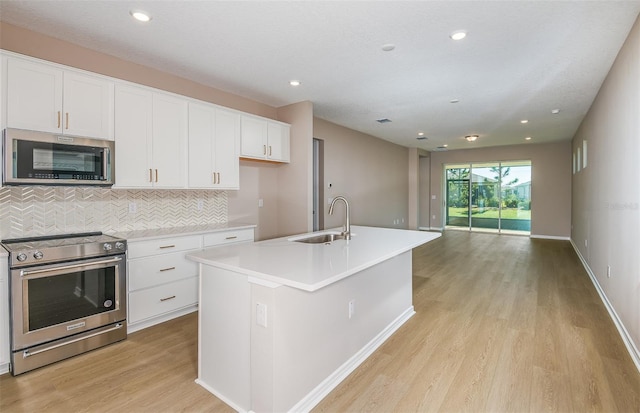 kitchen featuring white cabinetry, a center island with sink, light hardwood / wood-style floors, sink, and appliances with stainless steel finishes