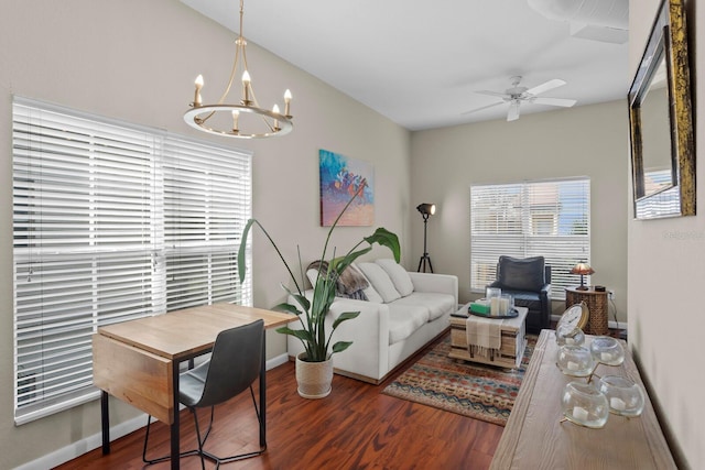 living room with dark hardwood / wood-style flooring and ceiling fan with notable chandelier