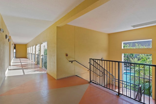 hall featuring lofted ceiling with skylight and concrete flooring