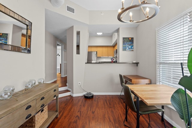 dining space featuring a notable chandelier and dark hardwood / wood-style floors