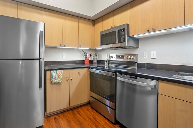 kitchen featuring light brown cabinetry, dark hardwood / wood-style floors, and appliances with stainless steel finishes