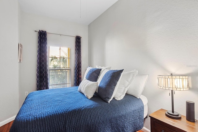 bedroom with hardwood / wood-style flooring and lofted ceiling