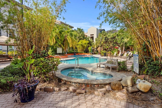 view of pool featuring a community hot tub and a patio area