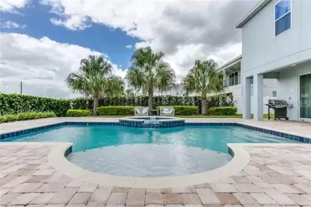 view of pool featuring an in ground hot tub and a patio area