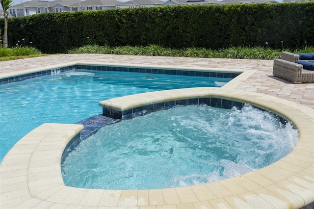 view of swimming pool with an in ground hot tub