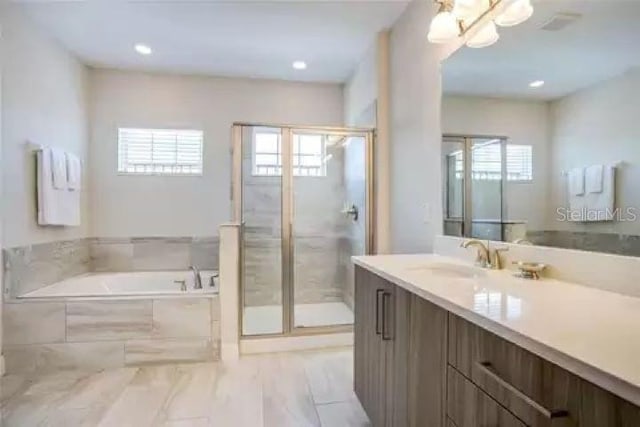 bathroom featuring vanity and independent shower and bath