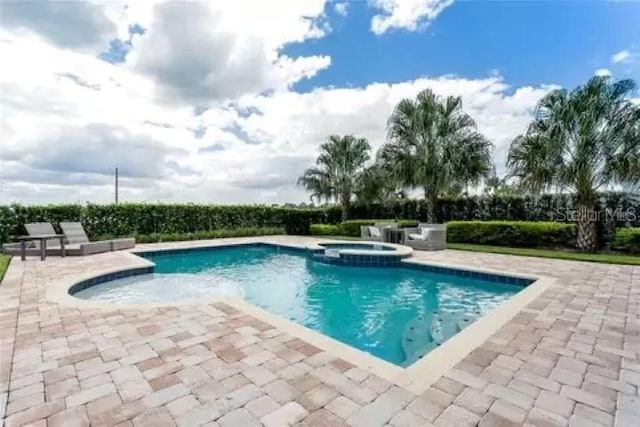 view of swimming pool featuring an in ground hot tub and a patio area