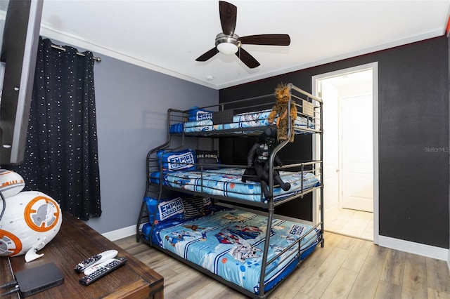 bedroom with hardwood / wood-style flooring, ceiling fan, and crown molding