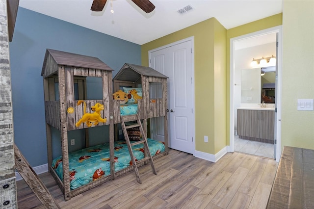 bedroom with ceiling fan, light hardwood / wood-style floors, ensuite bathroom, and a closet