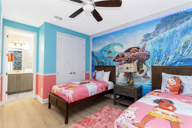 bedroom featuring hardwood / wood-style floors, a closet, ensuite bath, and ceiling fan