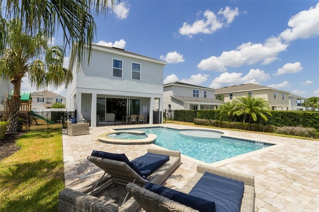 view of swimming pool featuring a patio area, a playground, and an in ground hot tub