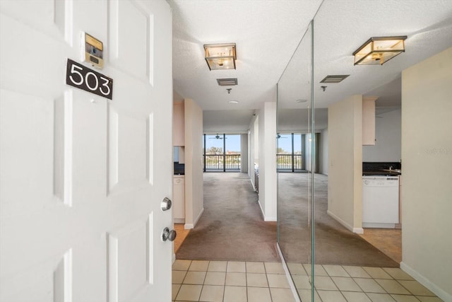 hall featuring a textured ceiling and light carpet