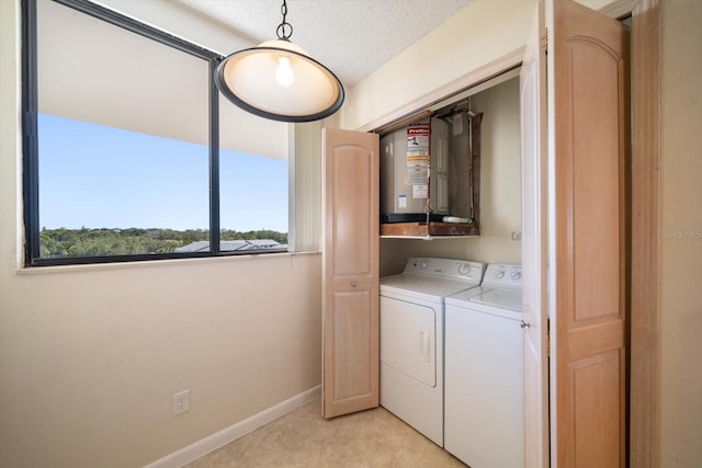 clothes washing area featuring washing machine and dryer, a textured ceiling, and light carpet