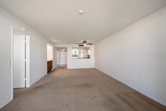 unfurnished living room with light carpet, ceiling fan, and a textured ceiling