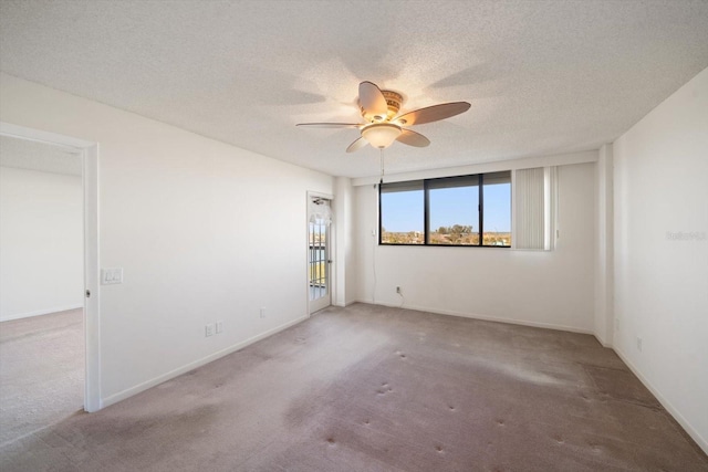 carpeted spare room with a textured ceiling and ceiling fan