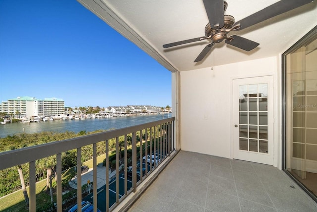 balcony with ceiling fan and a water view