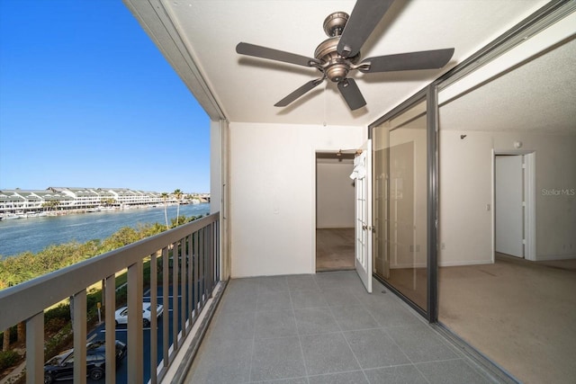 balcony featuring ceiling fan and a water view