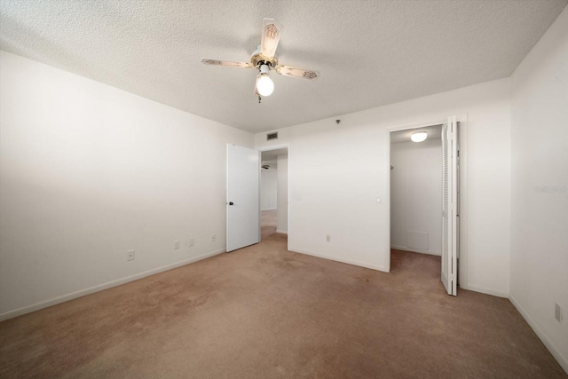 unfurnished bedroom with carpet, a textured ceiling, and ceiling fan