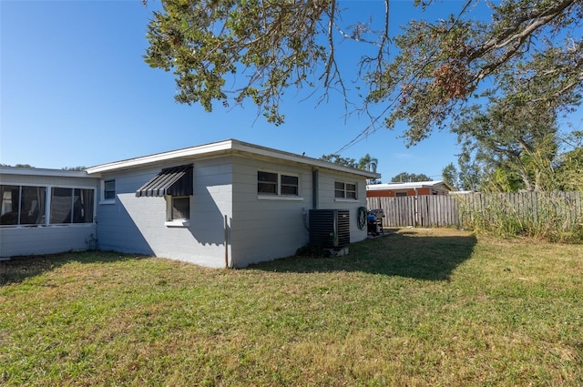 back of property featuring a yard, central AC, and a sunroom