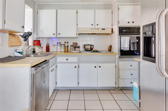 kitchen with appliances with stainless steel finishes, backsplash, sink, white cabinetry, and light tile patterned flooring