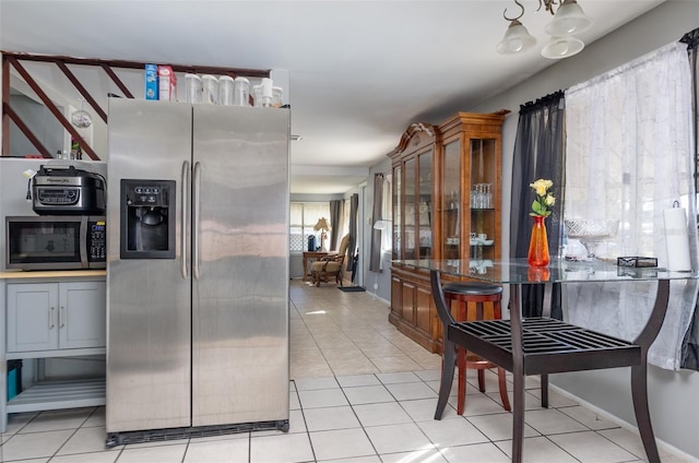 kitchen featuring light tile patterned floors, stainless steel appliances, and gray cabinets