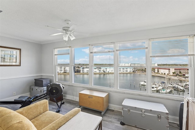 sunroom with a water view and ceiling fan