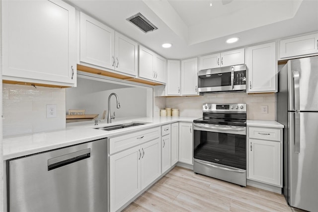 kitchen featuring white cabinets, backsplash, stainless steel appliances, and sink