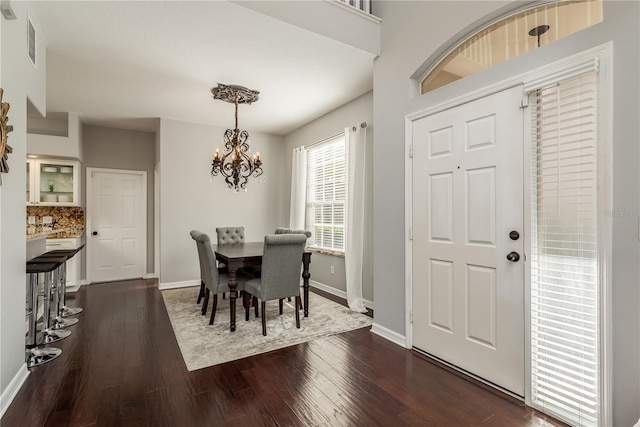 dining room featuring dark hardwood / wood-style flooring and an inviting chandelier