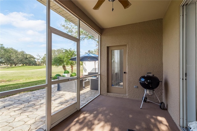 unfurnished sunroom with ceiling fan