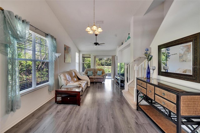 sitting room featuring plenty of natural light, wood-type flooring, ceiling fan with notable chandelier, and high vaulted ceiling