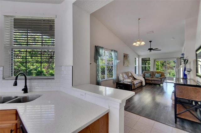 kitchen with light wood-type flooring, plenty of natural light, lofted ceiling, and sink