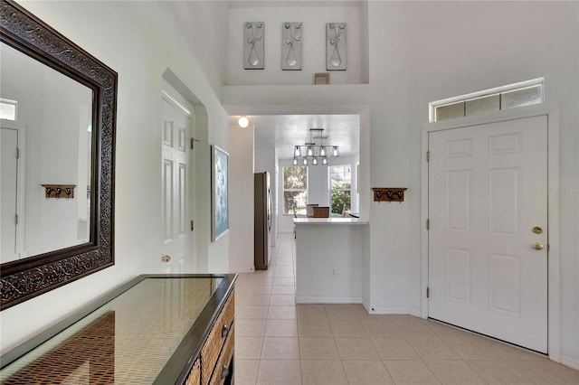 foyer entrance featuring light tile patterned floors and an inviting chandelier