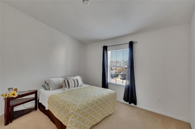 bedroom featuring light carpet and a textured ceiling