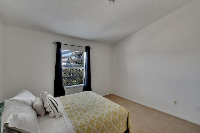 bedroom featuring a textured ceiling and light carpet