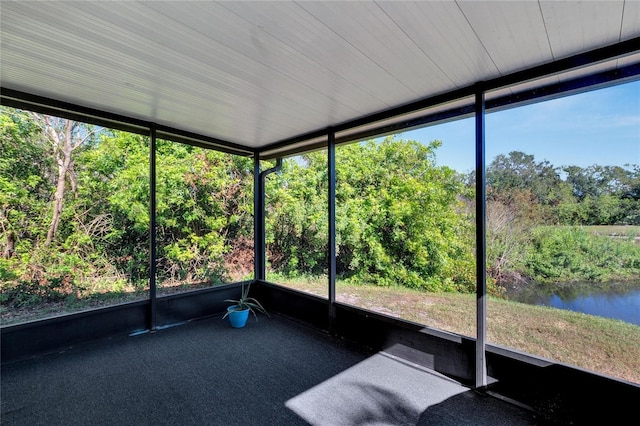 unfurnished sunroom featuring a water view