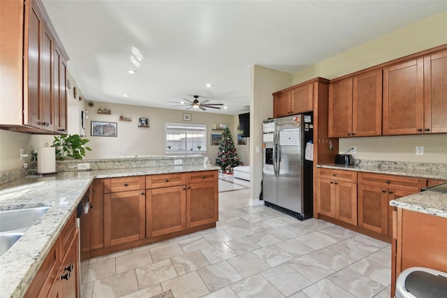 kitchen with ceiling fan, light stone counters, kitchen peninsula, and appliances with stainless steel finishes