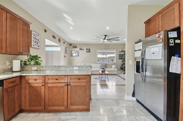 kitchen with kitchen peninsula, light stone counters, ceiling fan, and appliances with stainless steel finishes