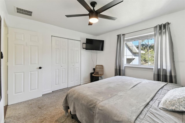 carpeted bedroom with ceiling fan and a closet