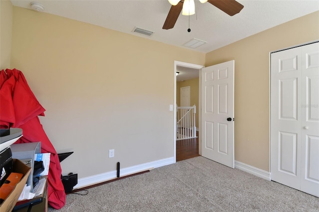 unfurnished bedroom with light carpet, a closet, and ceiling fan