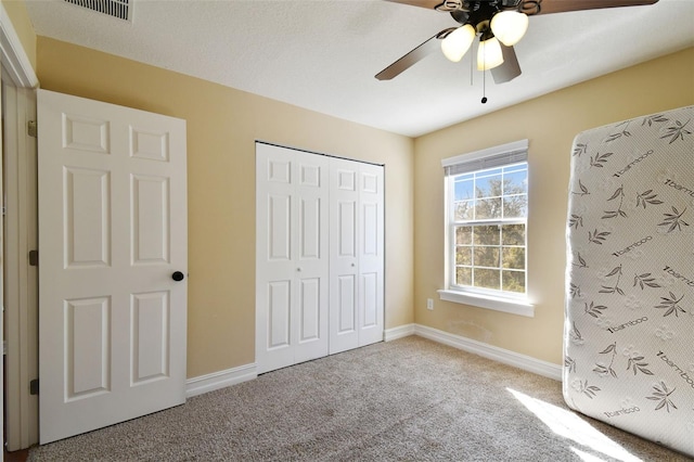 unfurnished bedroom with carpet floors, a closet, and ceiling fan