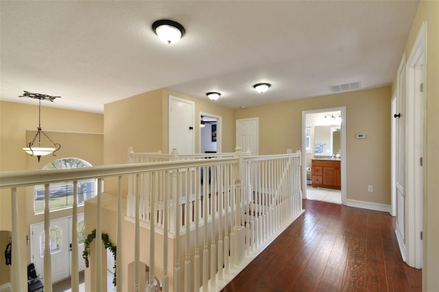 corridor featuring dark hardwood / wood-style flooring and a textured ceiling