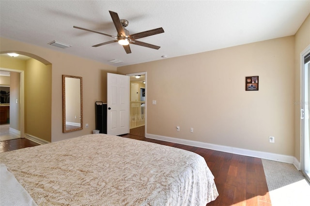 bedroom with a textured ceiling, ceiling fan, and dark hardwood / wood-style floors