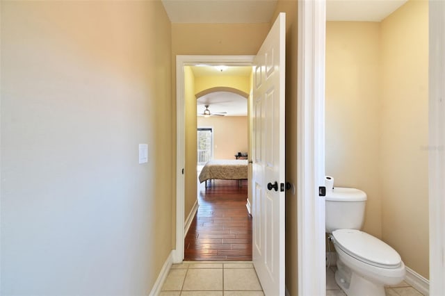 bathroom featuring ceiling fan, hardwood / wood-style floors, and toilet