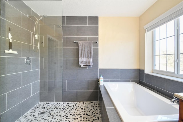 bathroom featuring shower with separate bathtub