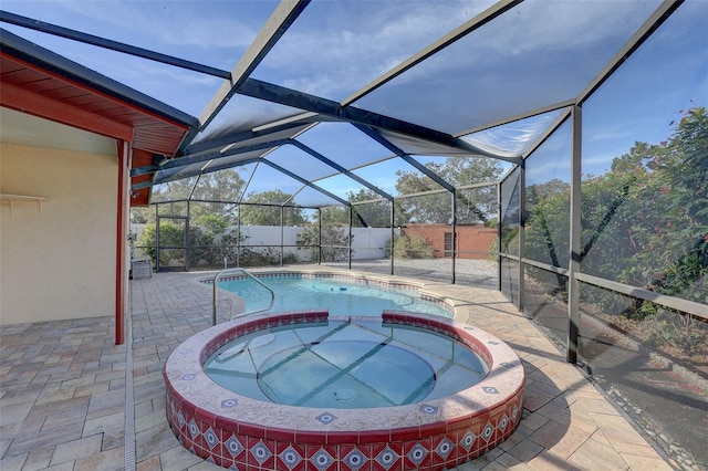 view of swimming pool featuring glass enclosure, an in ground hot tub, and a patio