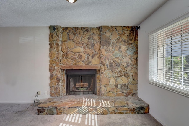 interior details featuring carpet flooring, a stone fireplace, and a textured ceiling