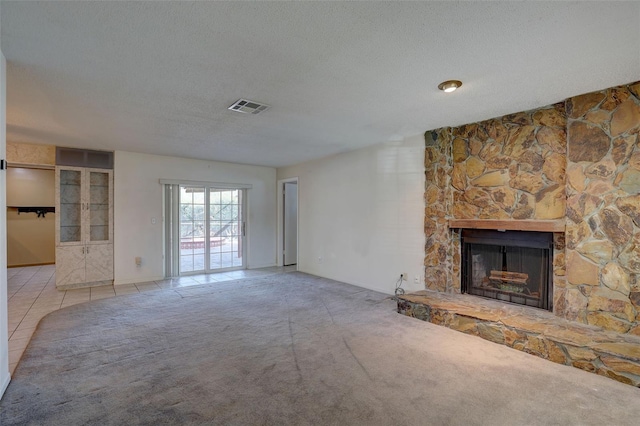 unfurnished living room featuring a fireplace, light tile patterned floors, a textured ceiling, and french doors