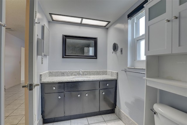 bathroom featuring tile patterned flooring, vanity, and toilet